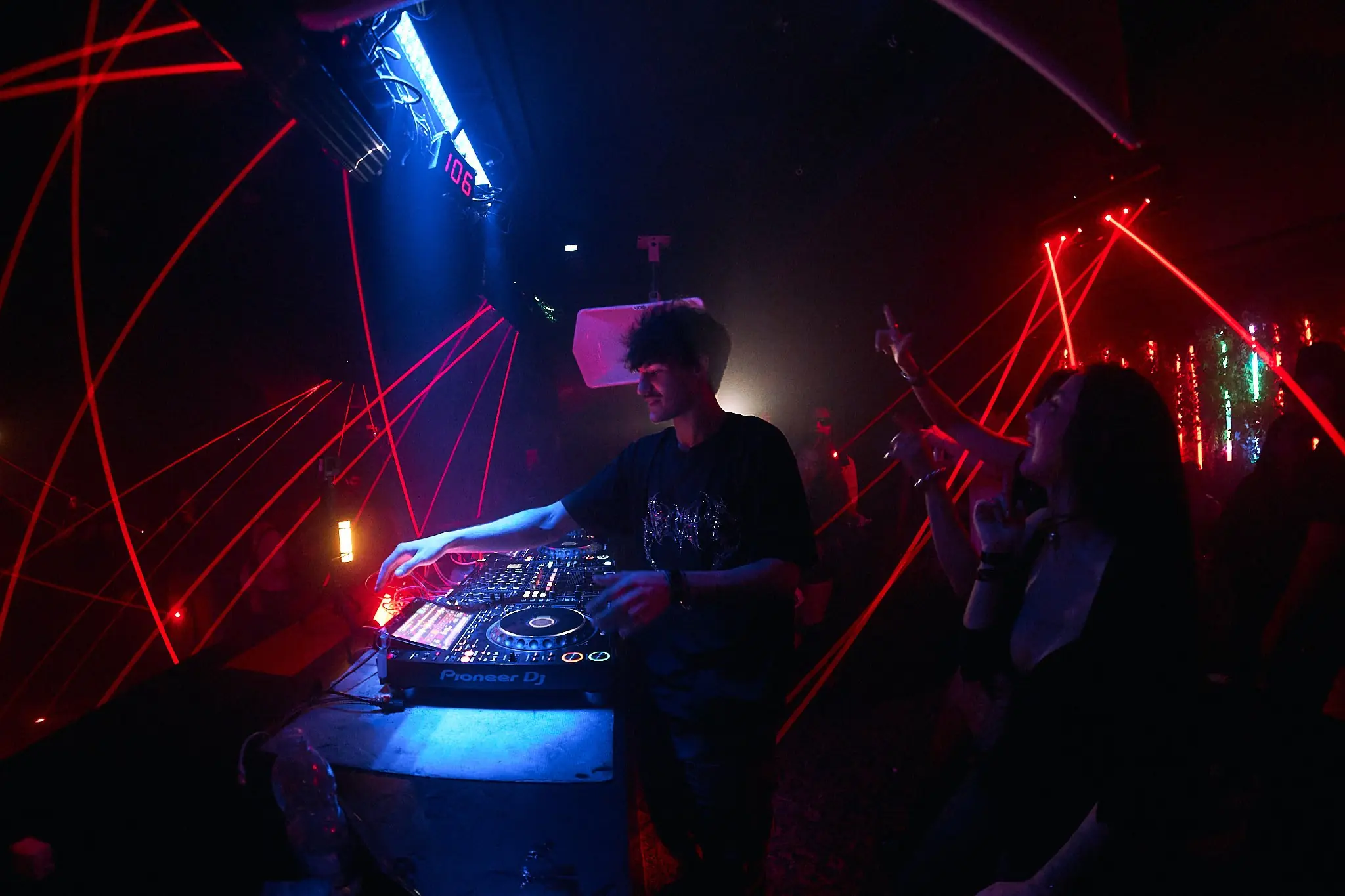 Dorom nos decks entre lasers vermelhos, público à direita